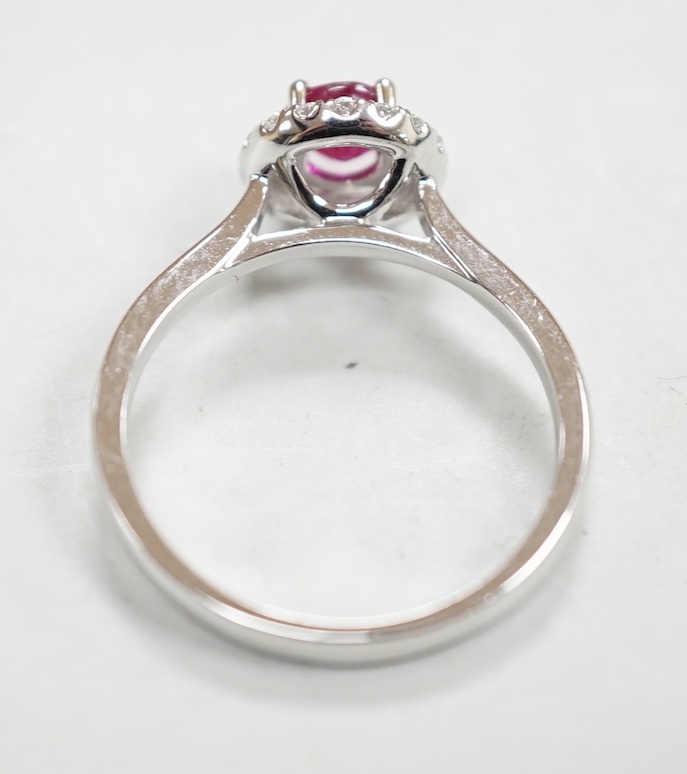 A modern 18ct white gold, ruby and diamond set circular cluster ring, size M, gross weight 3.1 grams.